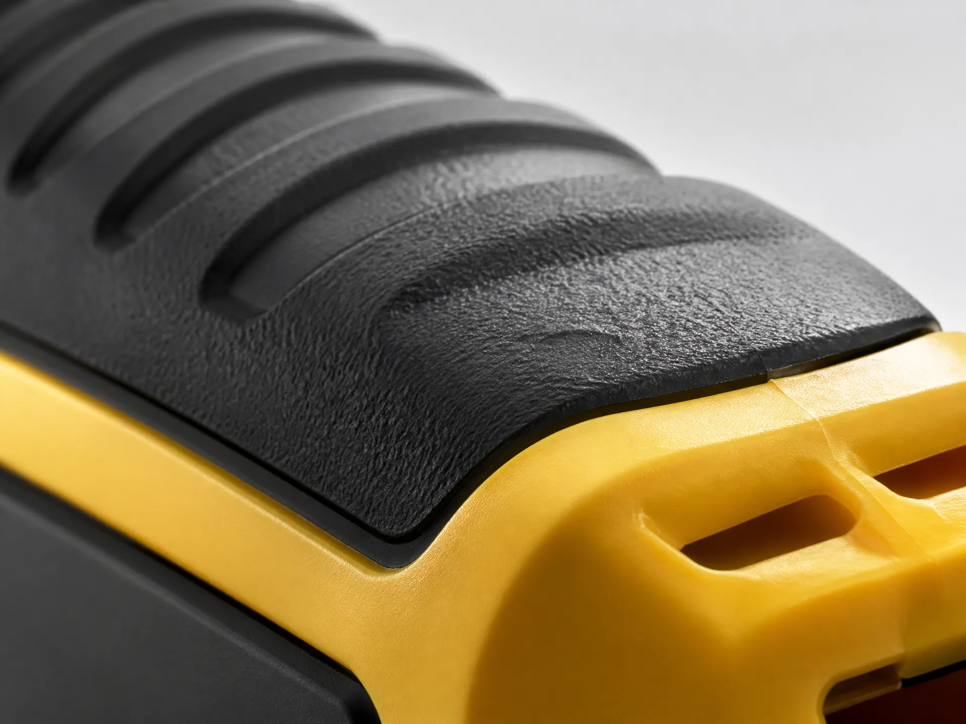 Rubber over plastic overmolding configuration for grip and sealing features